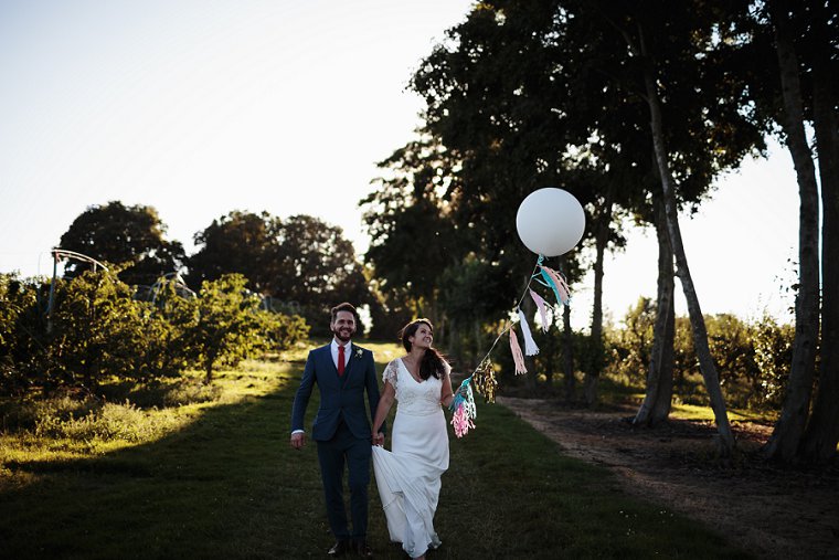 Bride and Groom holding white balloon at their wedding