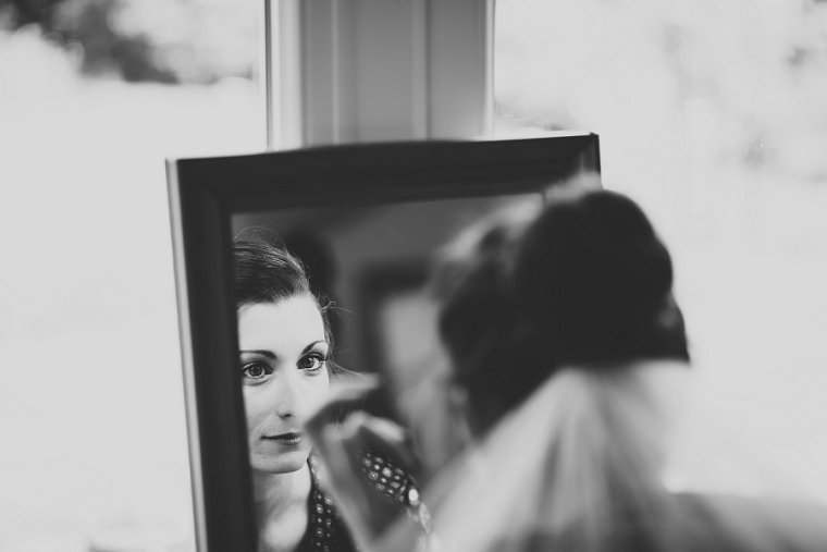 Bride looking in to mirror before her wedding at Ratsbury Barn