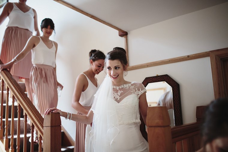Bride walking down stairs with her bridesmaids before her wedding