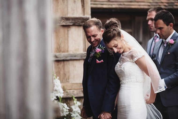 Bride and Groom laughing during wedding service at Ratsbury Barn