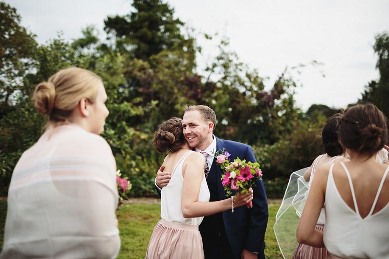 Groom hugging bridesmaid