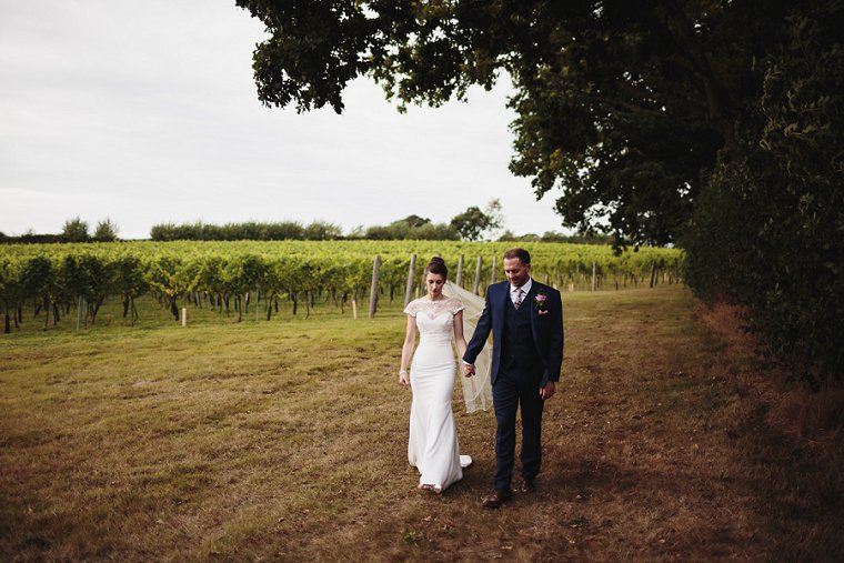 Bride and groom holding hands and walking