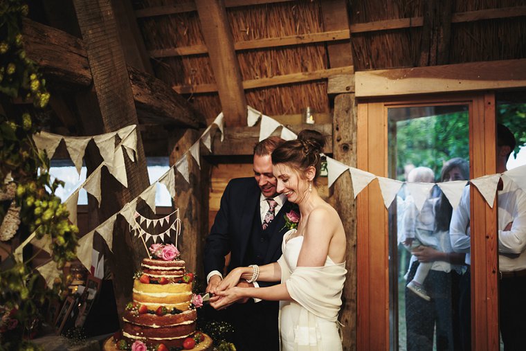 Bride and groom cutting wedding cake at Ratsbury Barn