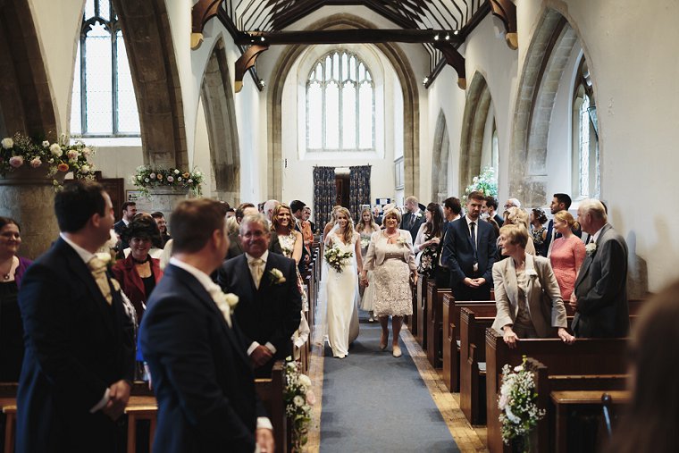 Bride walking down aisle with her mum