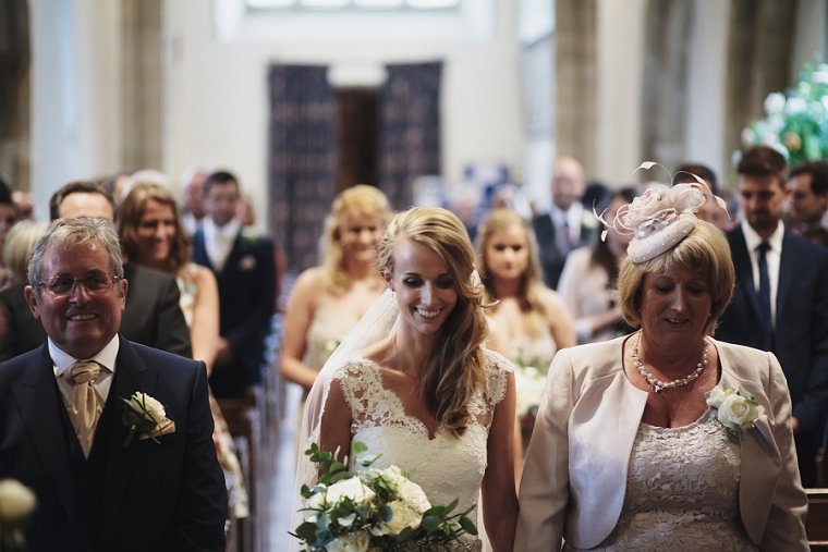 Bride smiling as she walks down aisle