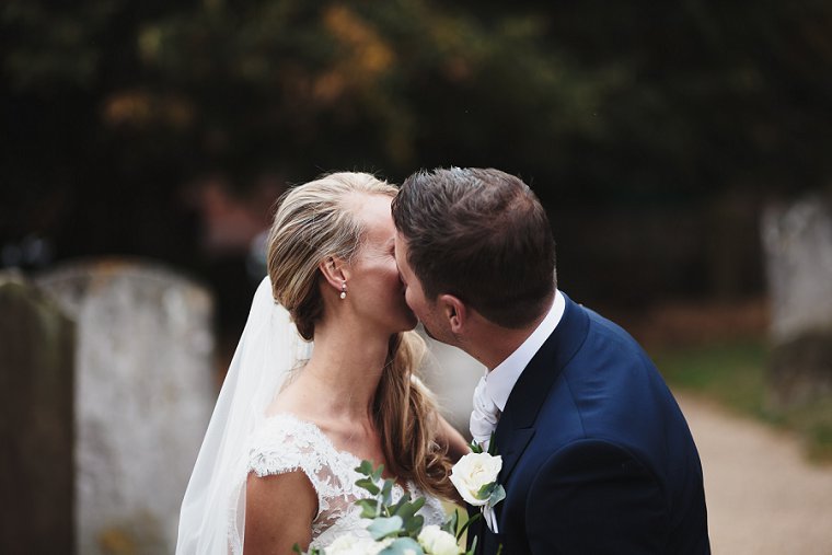 Bride and Groom sharing a kiss outside the church after their Squerryes Court Wedding