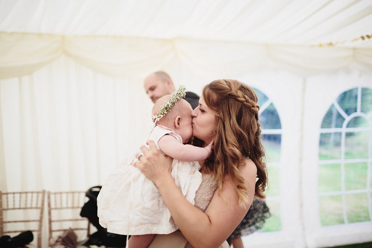 bridesmaid kissing her baby daughter flower girl at Squerryes Court wedding