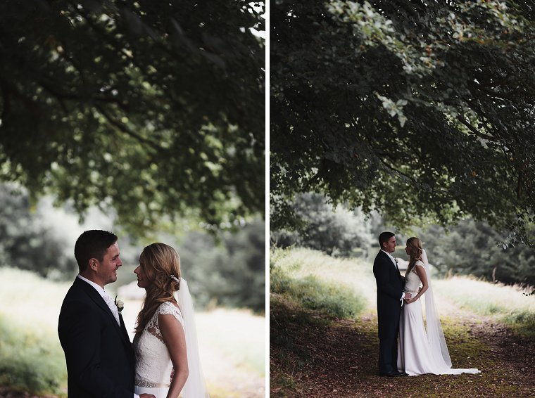 Bride and Groom laughing together under tree during rain on their wedding day