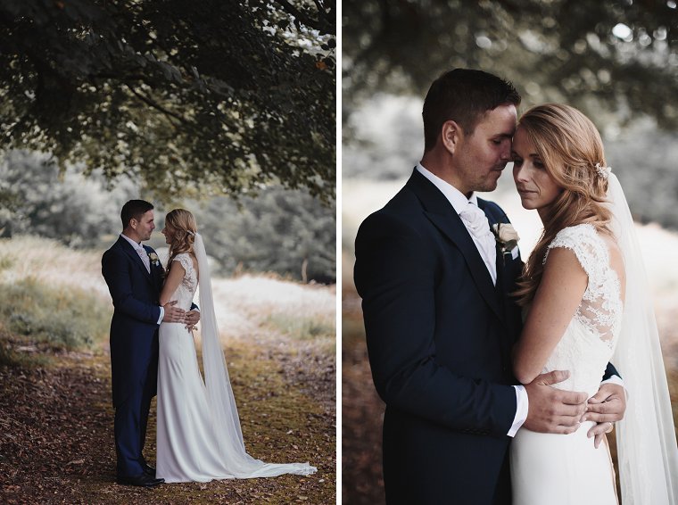 Rain on their wedding day. Wedding portrait of bride and Groom hugging taking cover under tree
