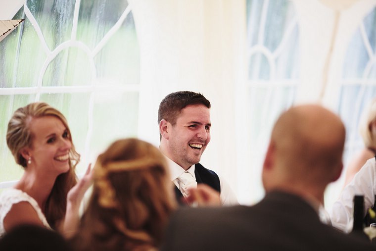 Groom laughing during mother of the brides speech