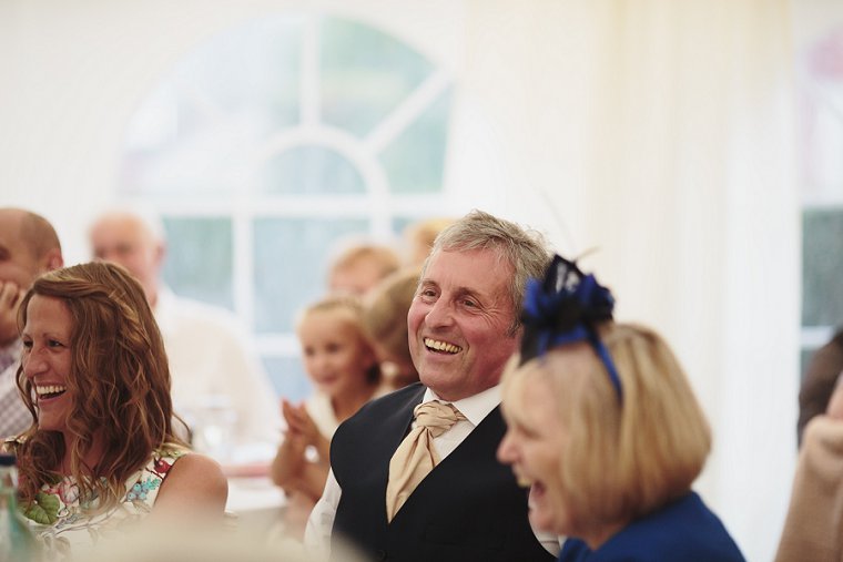 Father of the groom laughing during mother of the brides speech