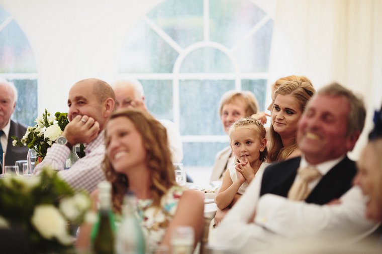Flower girl smiling during mother of the brides speech