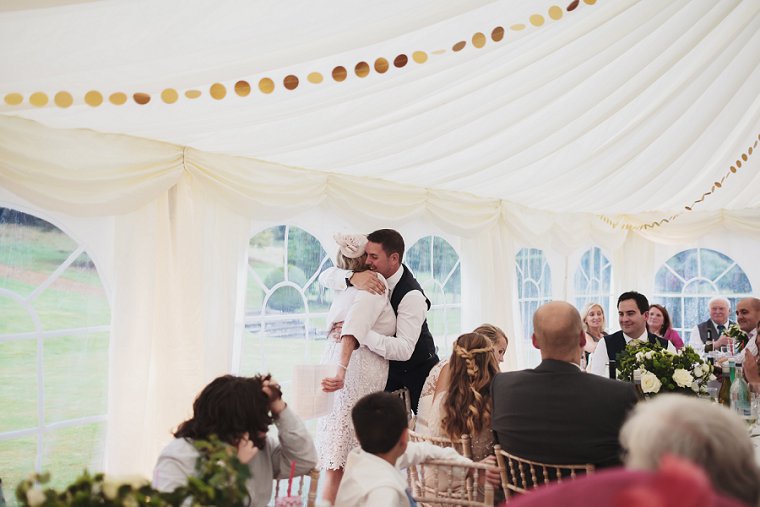 Groom hugging bride after mother of the brides speech