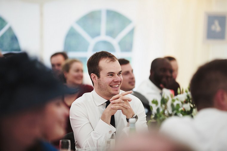 Wedding guest laughing during grooms speech at Squerryes Court Wedding