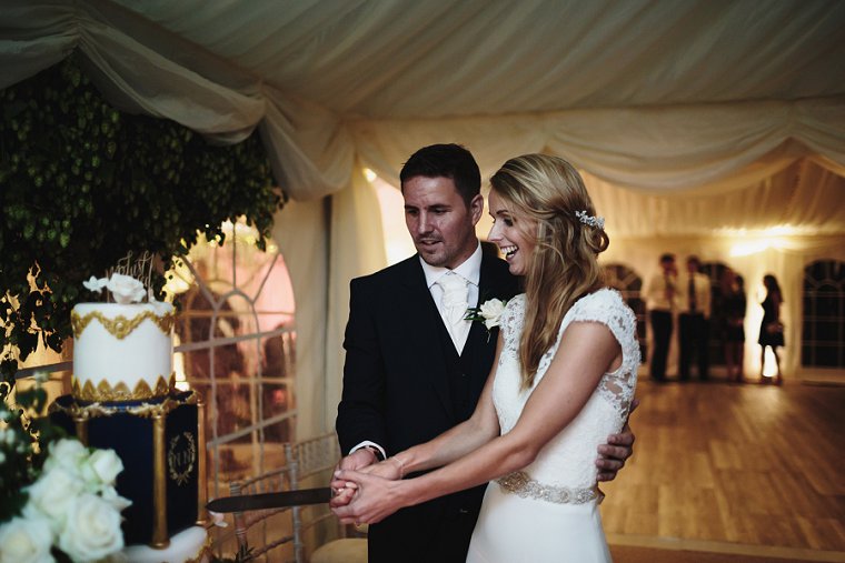 Bride and groom laughing during cake cutting