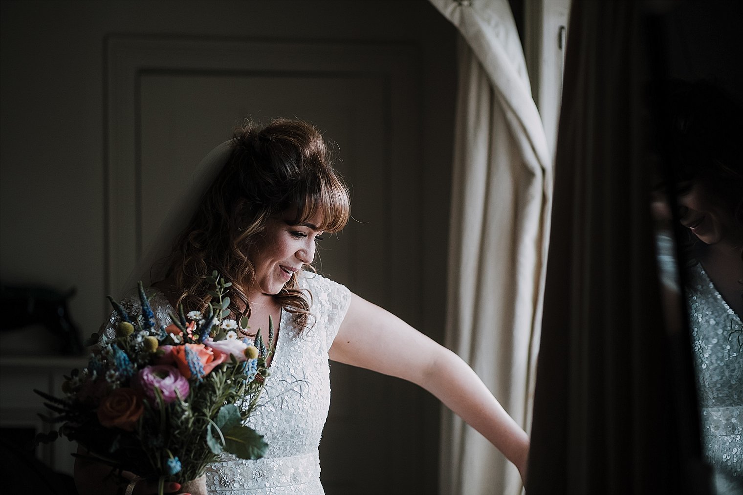 Bride looking out the window of the george hotel in camber