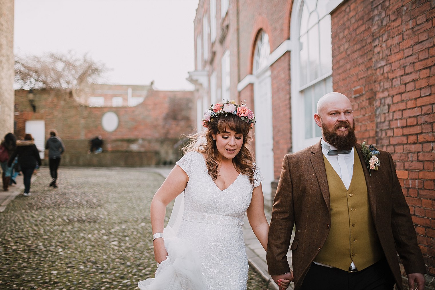 Bride and groom in Rye holding hands during their wedding portraits