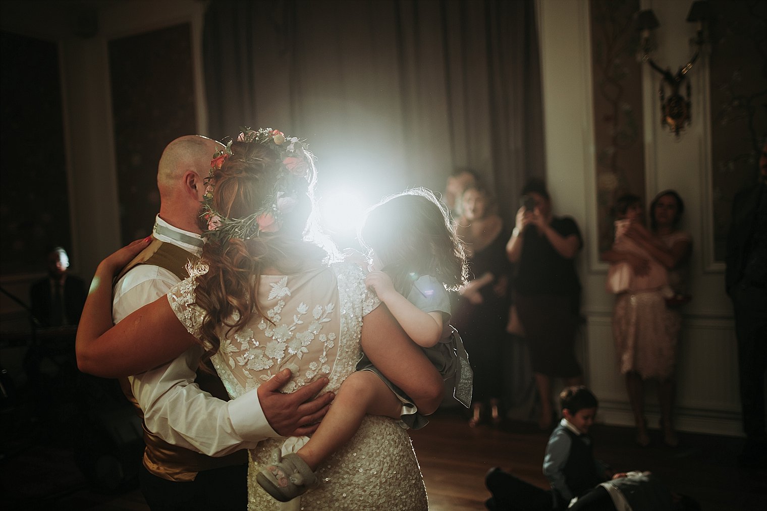 Bride and groom holding their daughter