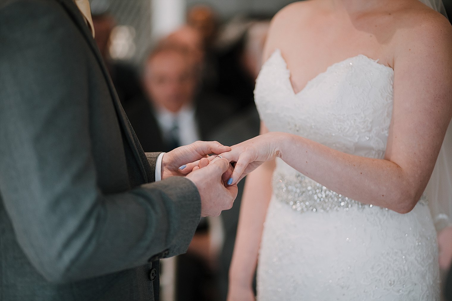 Groom placing wedding ring on the bride