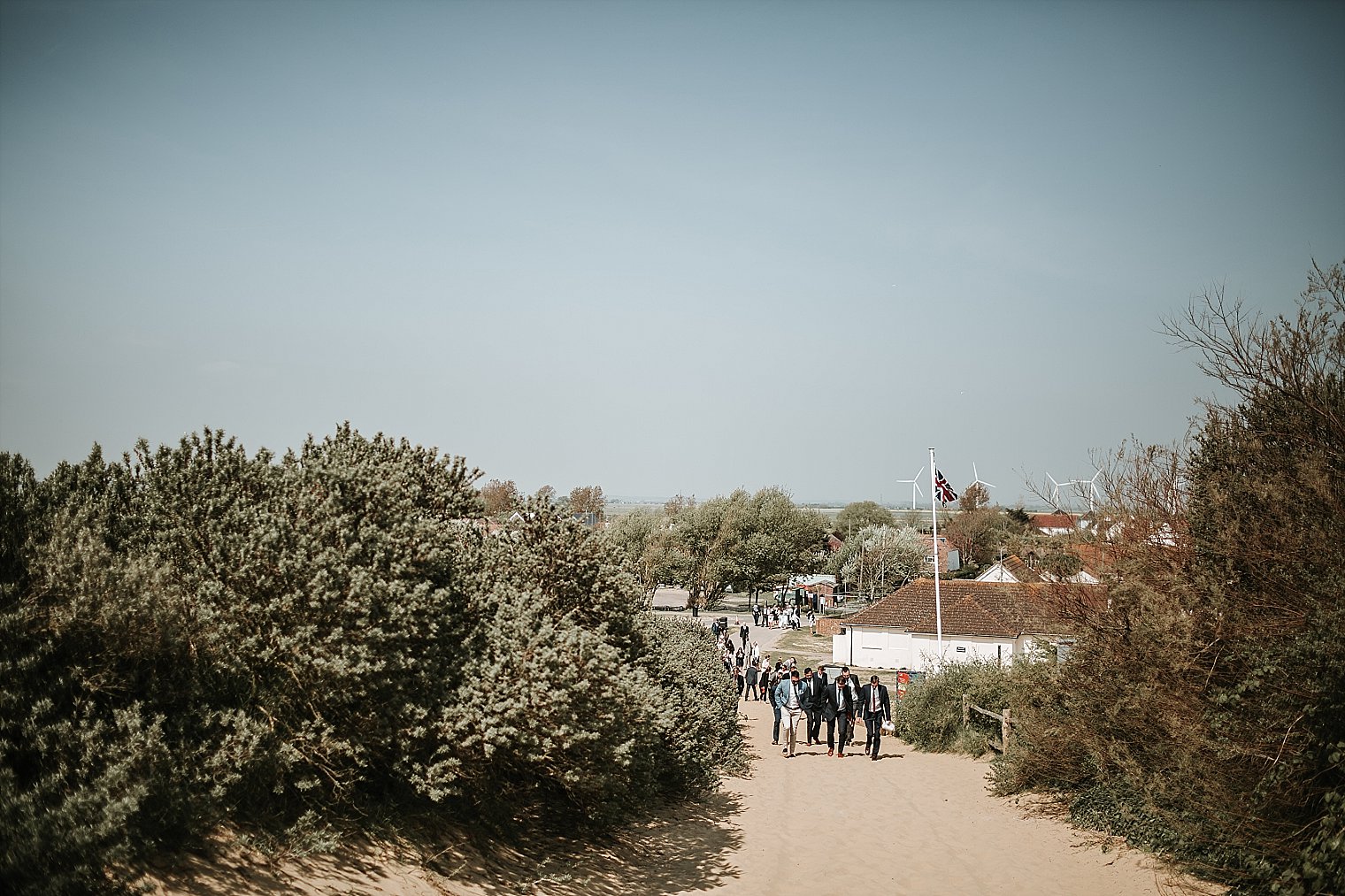Wedding guests walking towards the drinks reception on Camber Sands