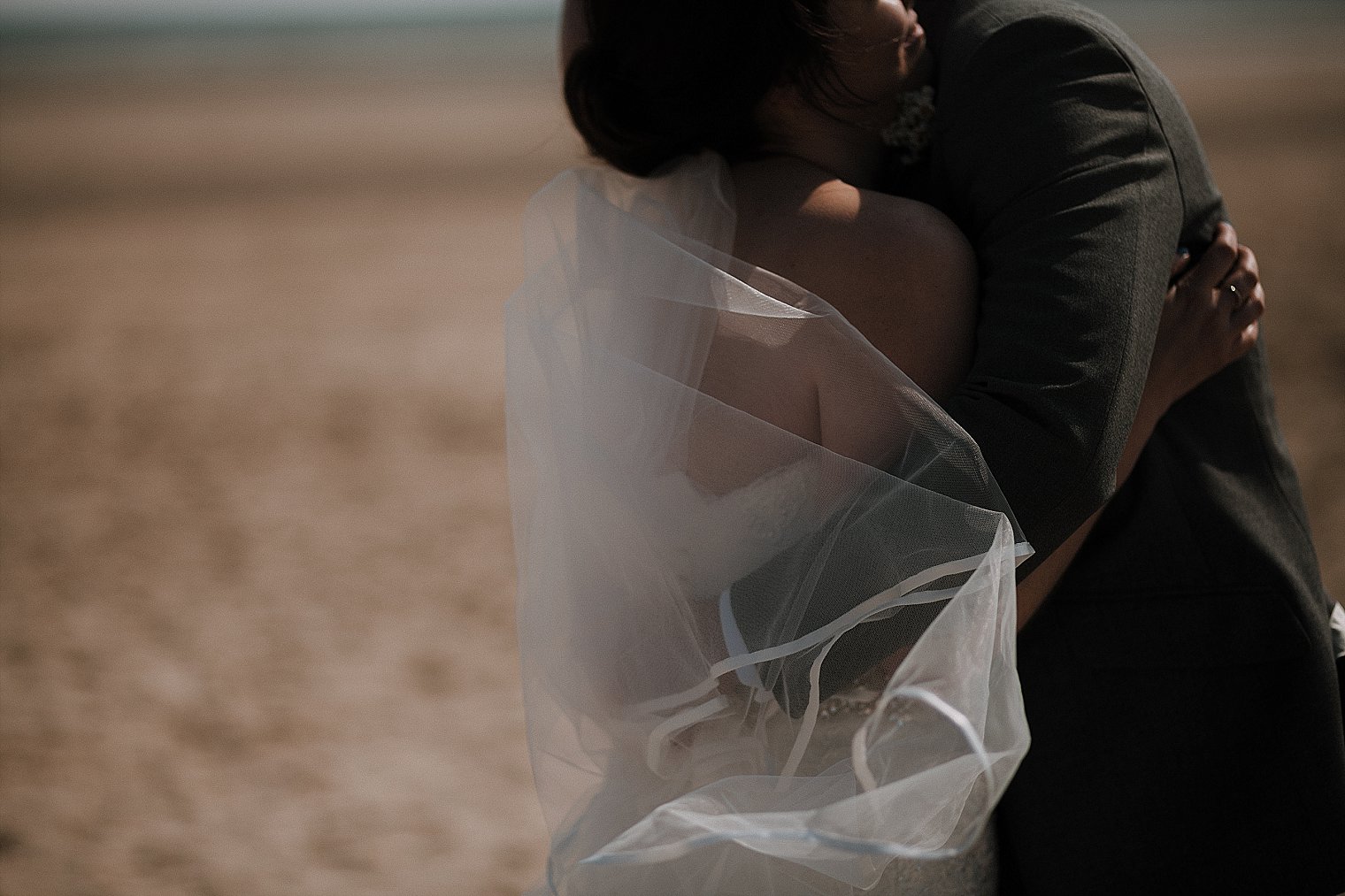Wedding portrait of bride and groom hugging