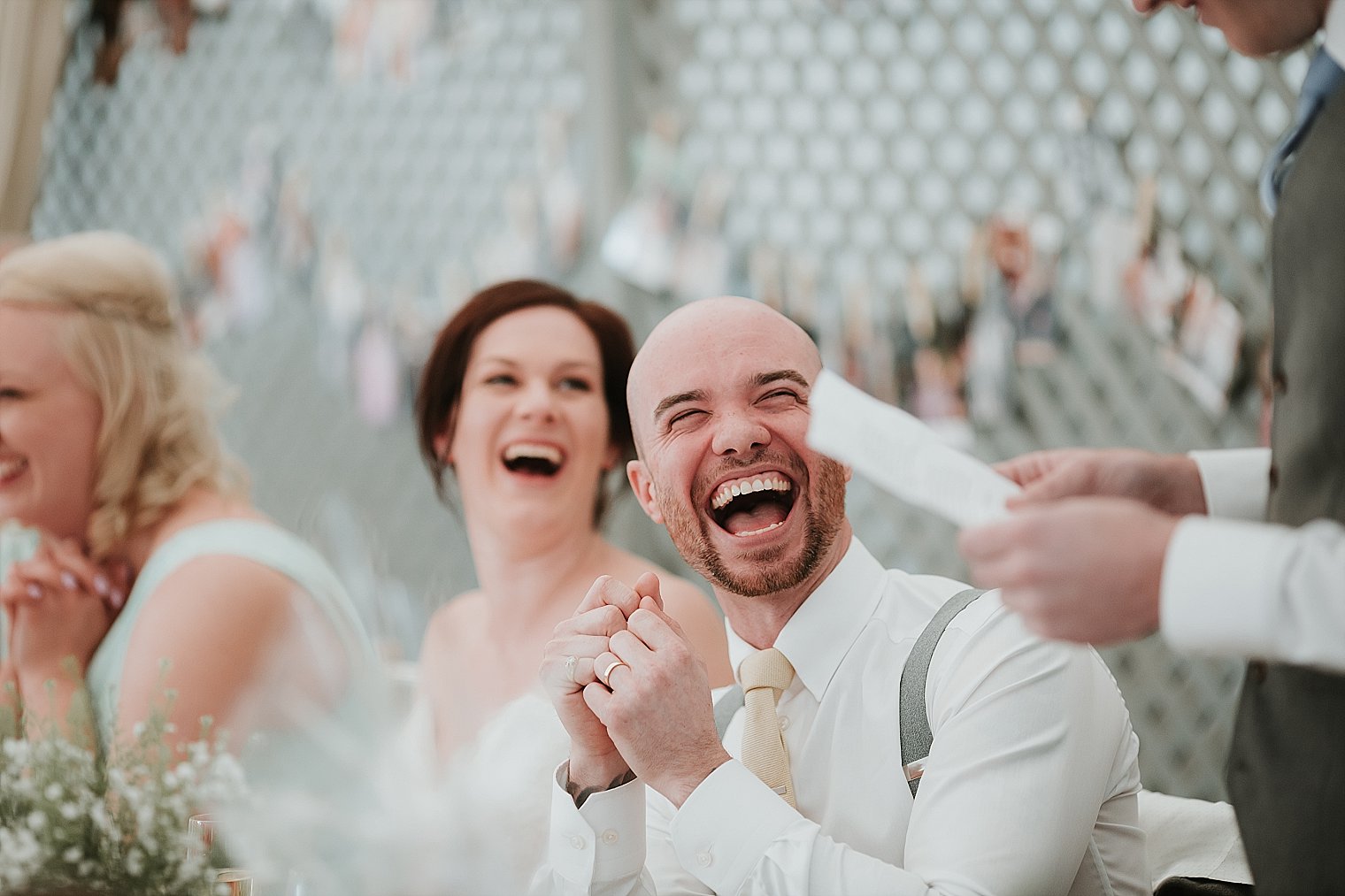 Groom laughing during best mans speech