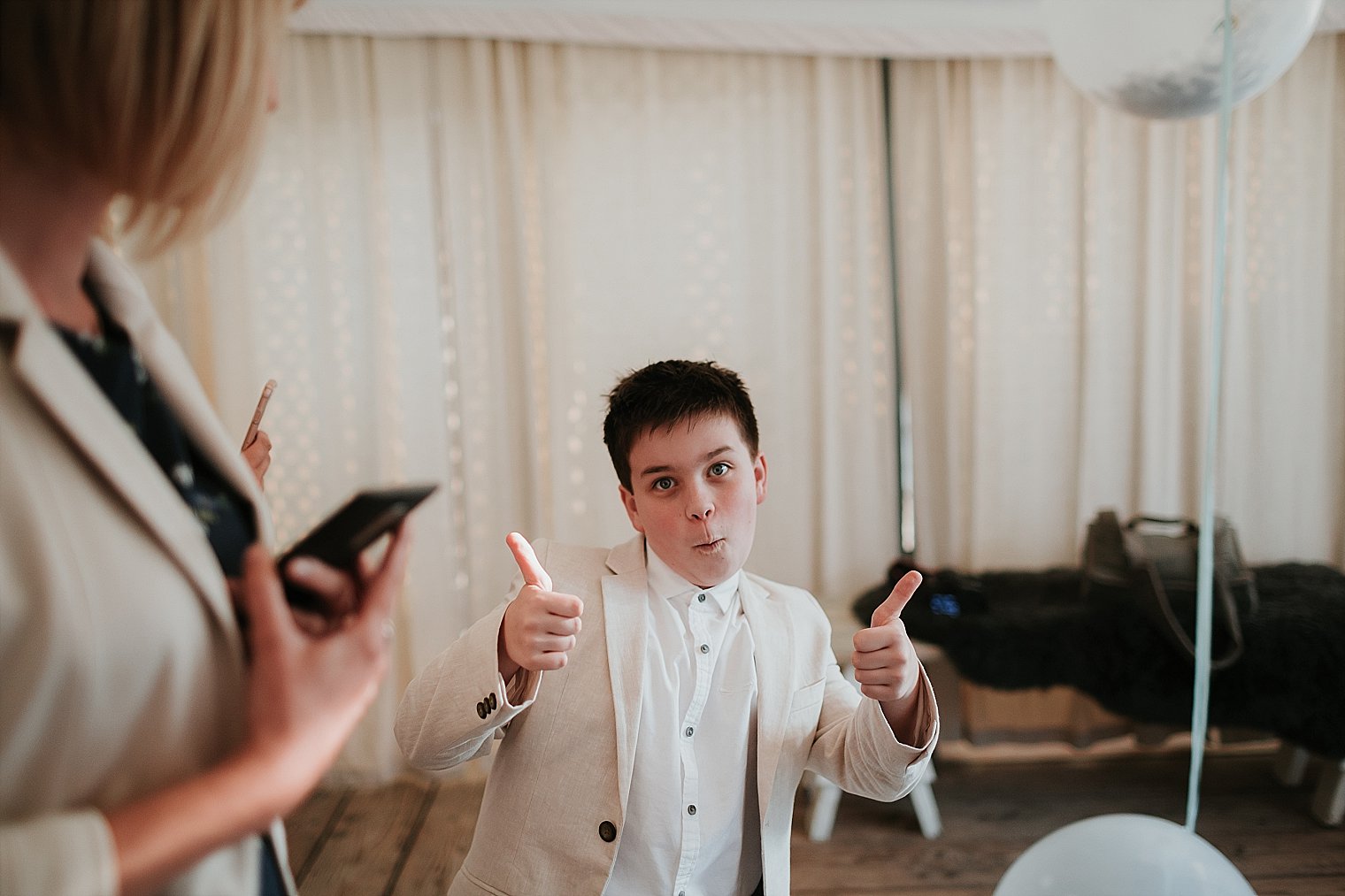 Young wedding guest giving the thumbs up