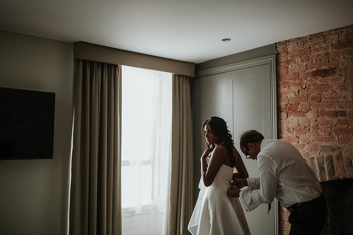 Bride putting wedding dress on