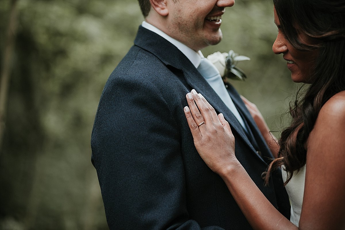 bride placing hand on chest of groom