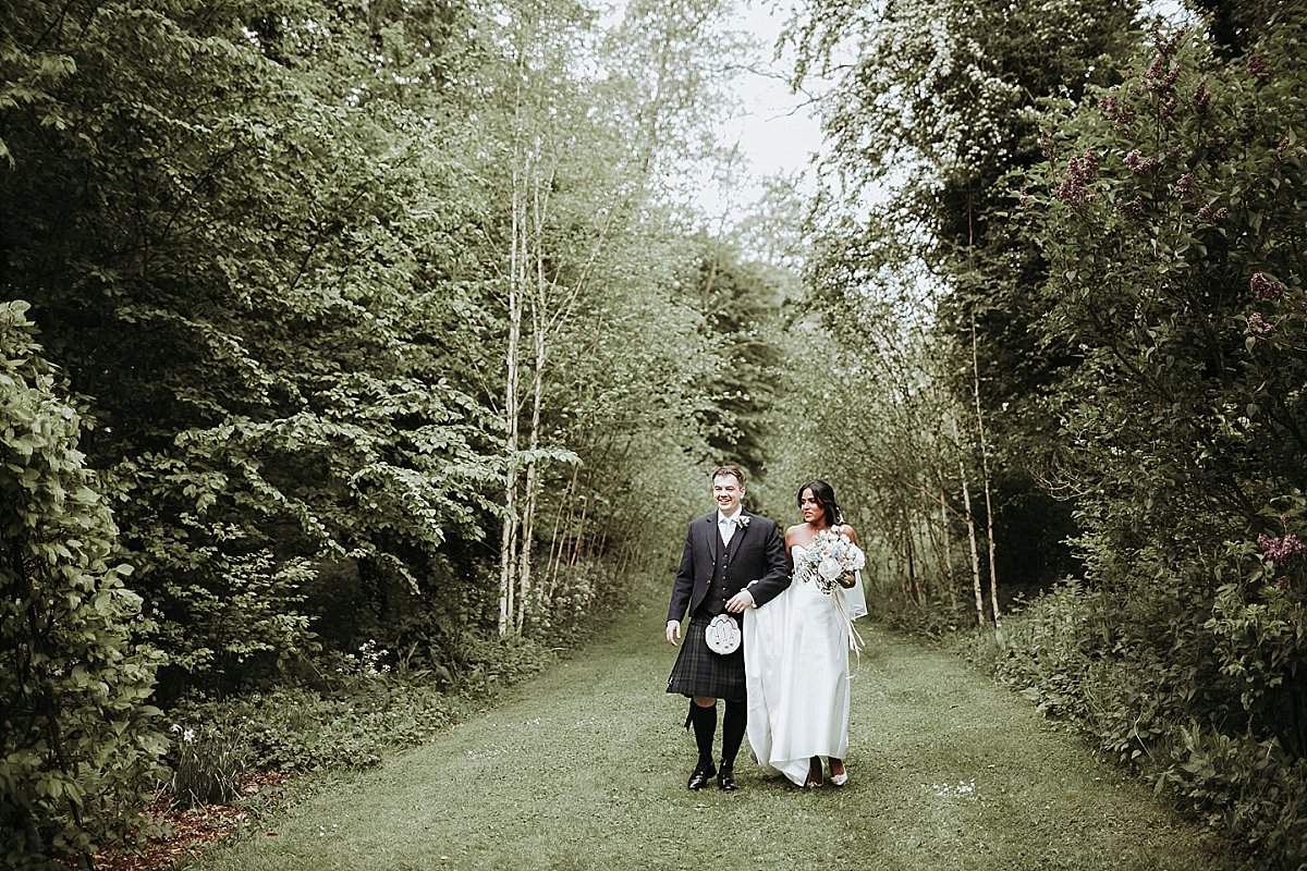 Bride and groom waling arm in arm