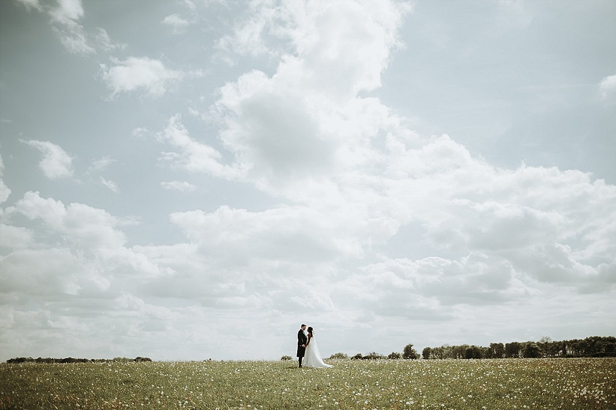 Bride and groom posing in field
