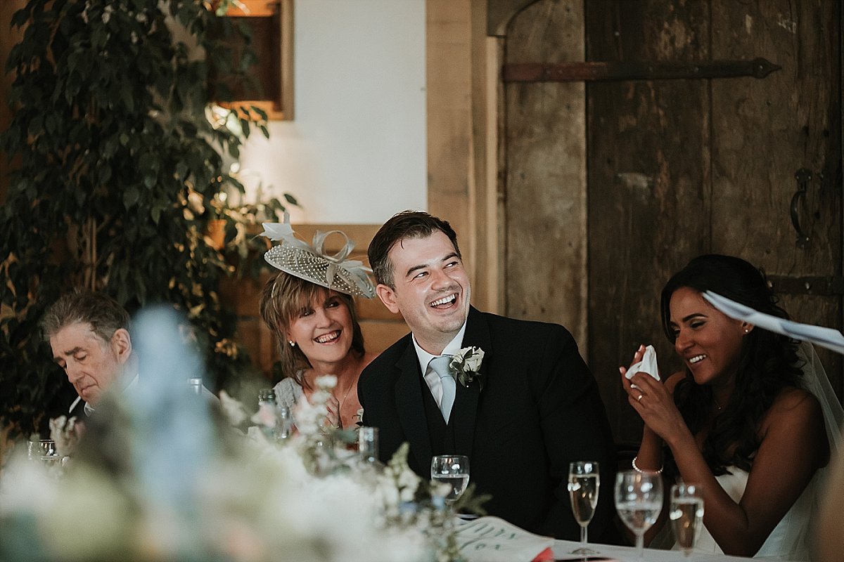 Groom laughing during speech