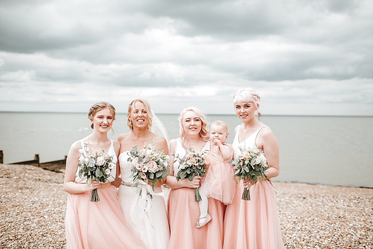 Bride and Bridesmaids posing on the beach at Whitstable