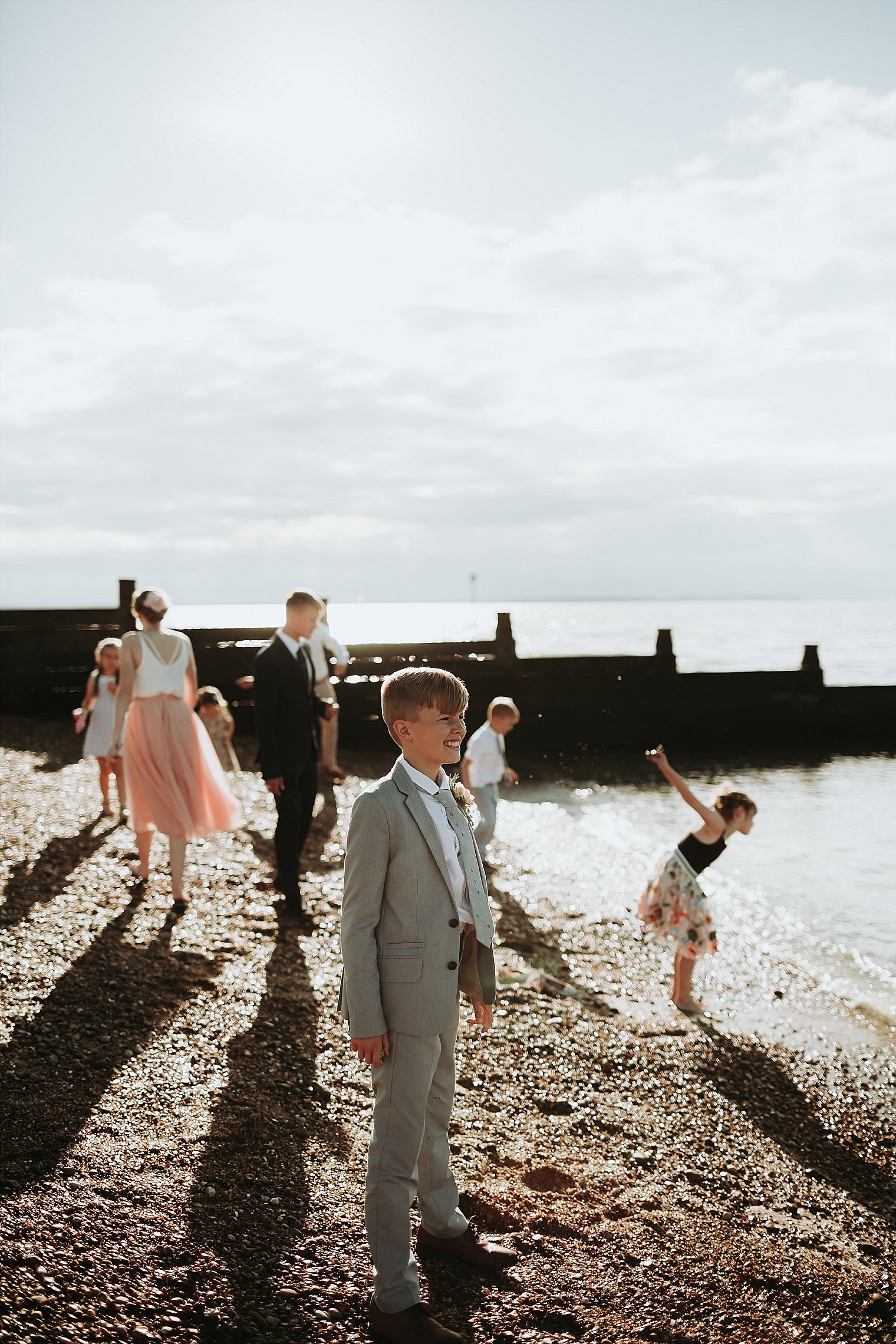 Wedding guest throwing stones on the beach at whitstable