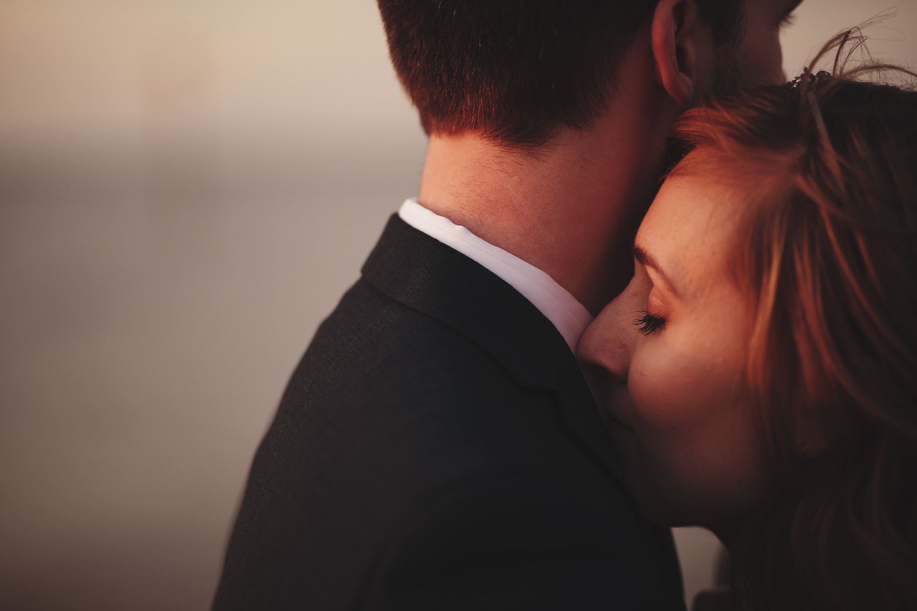 Bride resting her head on the shoulder of the groom on Whitstable beach