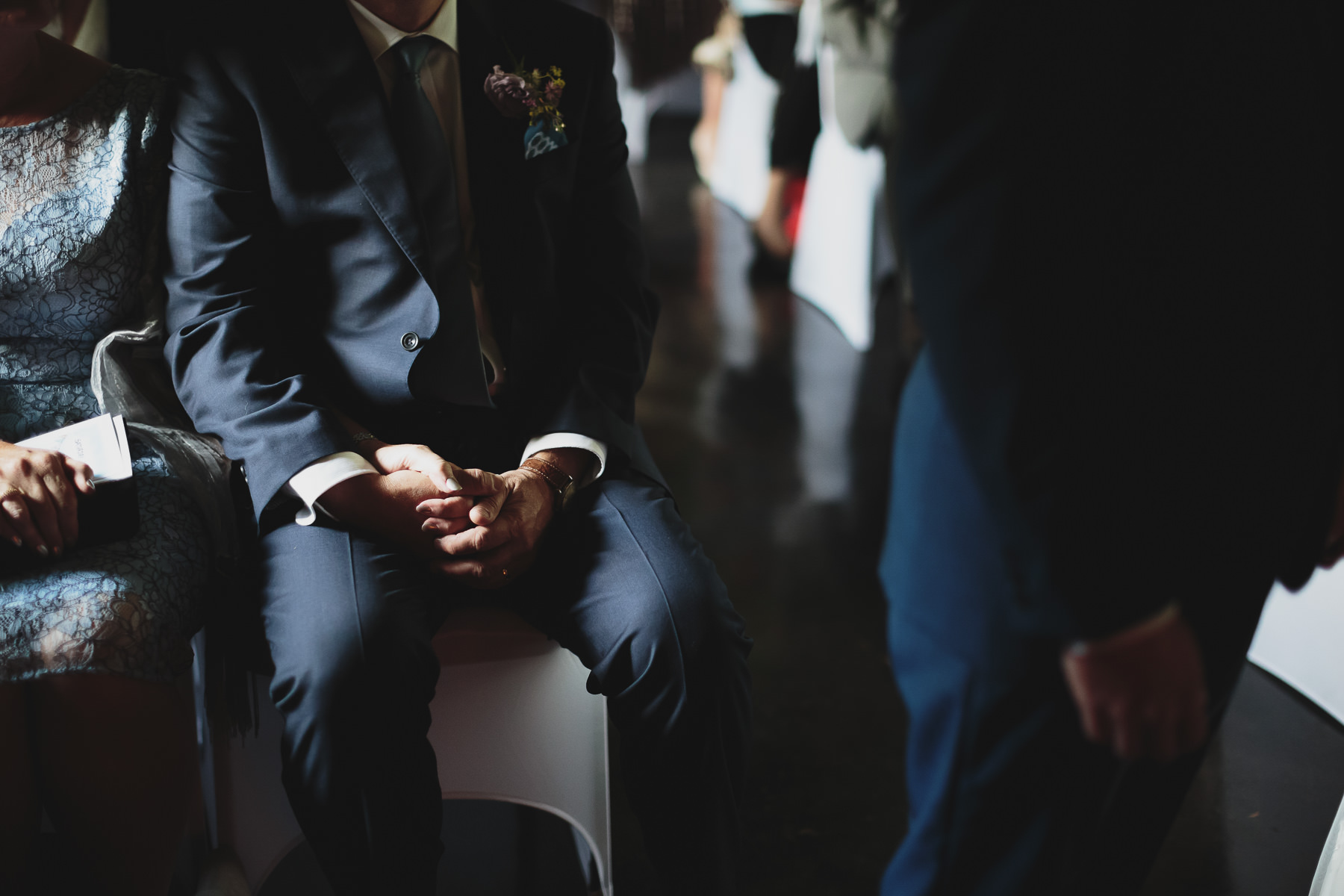 Mother and father of the groom holding hands during the wedding ceremony