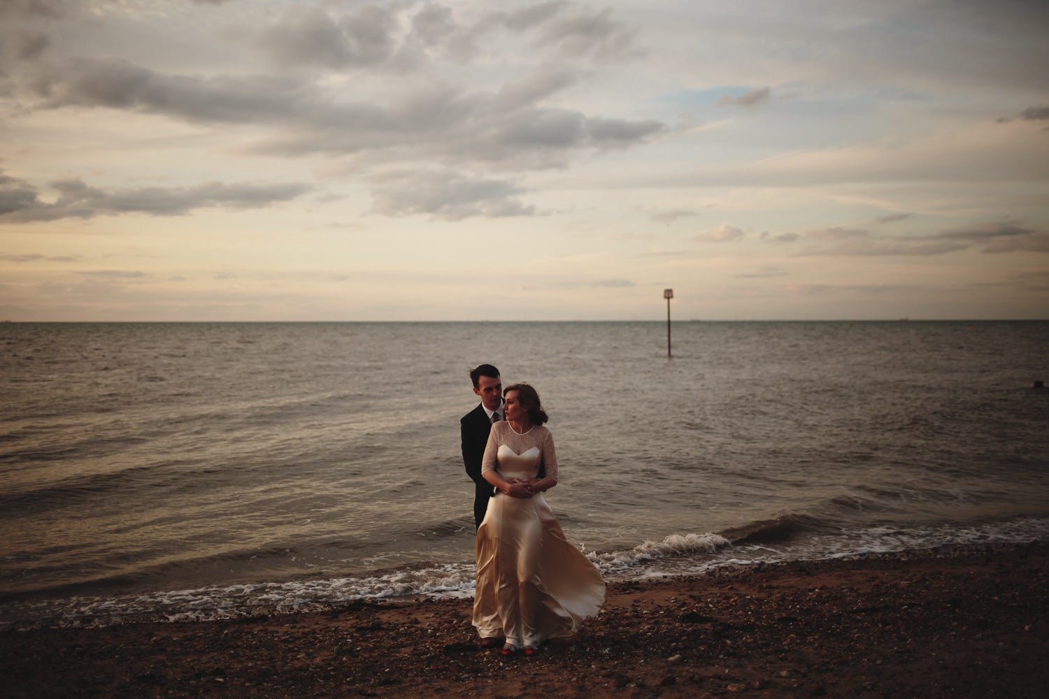 Portriat of a couple hugging on the beach at Whitstable
