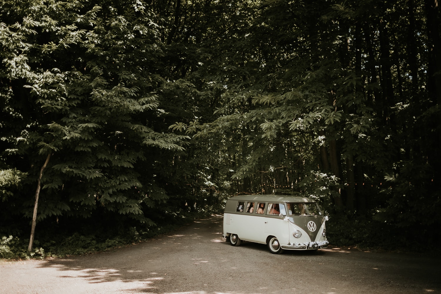 Vintage VW campervan driving through woodland