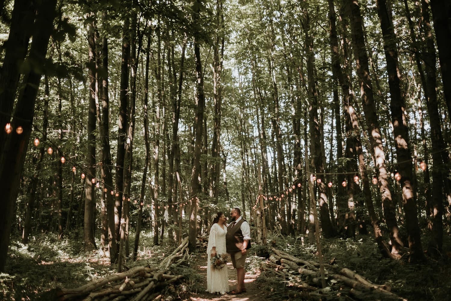 Bride and Groom in a woodland surrounded by festoon lights at The Dreys