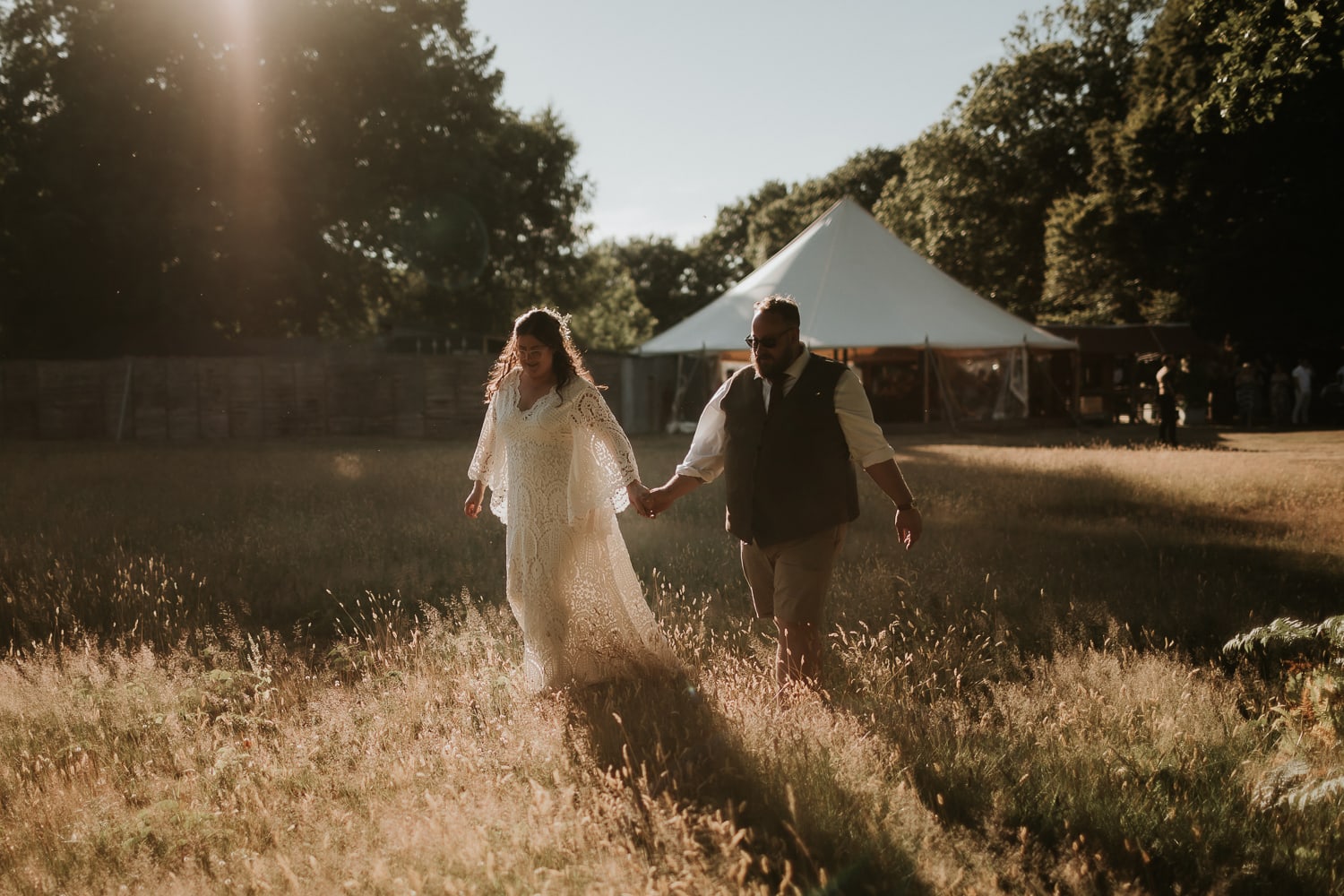 Bride and Groom walking hand in hand at sunset at The Dreys