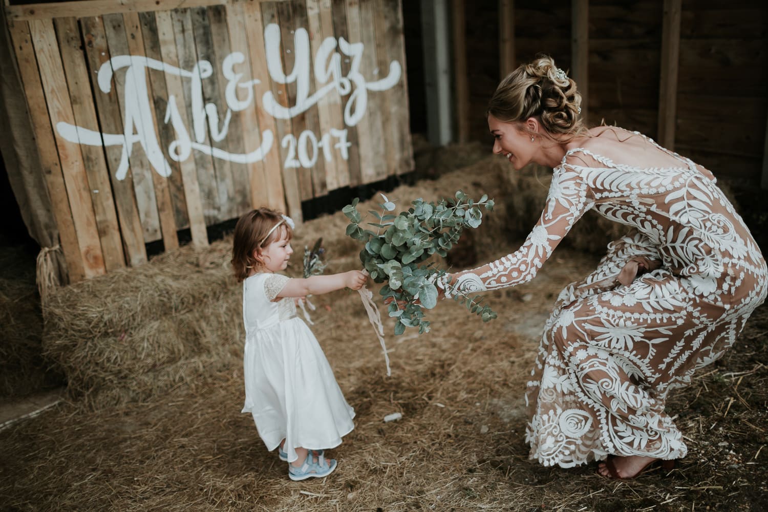 Bride handing her wedding flowers to her flower girl