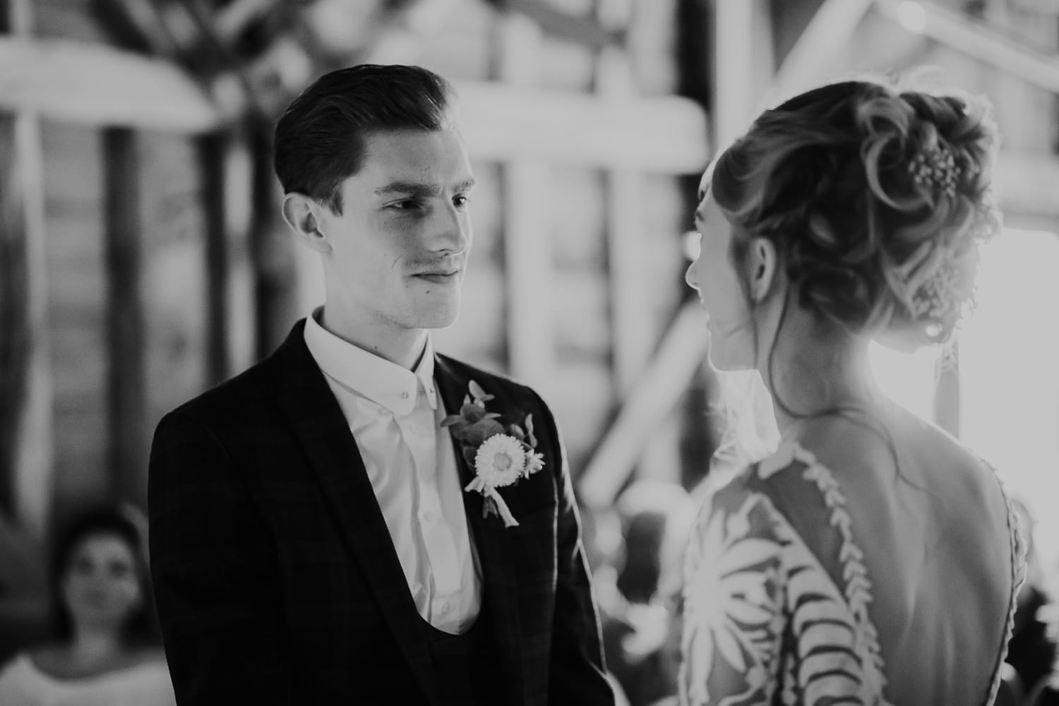 Groom looking at bride during wedding ceremony as they exchange vows