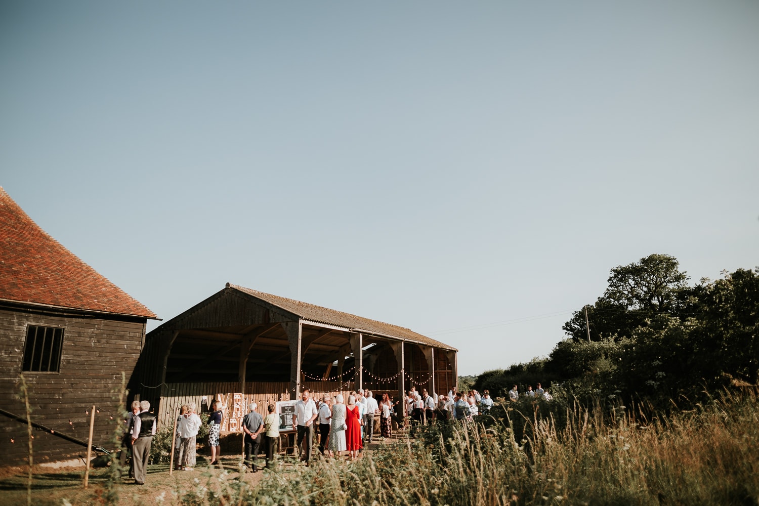 Wedding guests outside The Great Barn Rolvenden having a drink